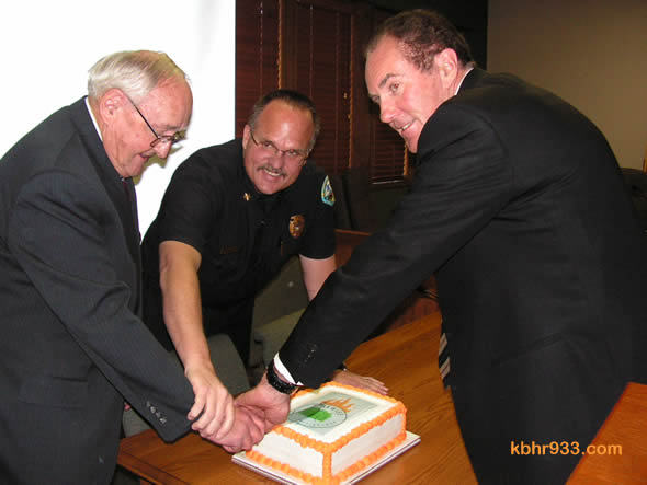 The Firewise honor was then celebrated with a cake, which Chief Willis (center) cuts with CSD President John Day and past President Rick Ollila